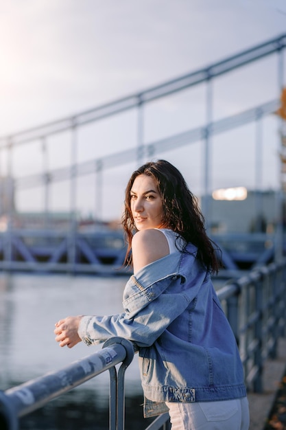 Jonge mooie glimlachende hipster vrouw in trendy zomerkleding Sexy zorgeloos model poseren op de europa straat achtergrond bij zonsondergang Positieve brunette vrouw Vrolijk en gelukkig