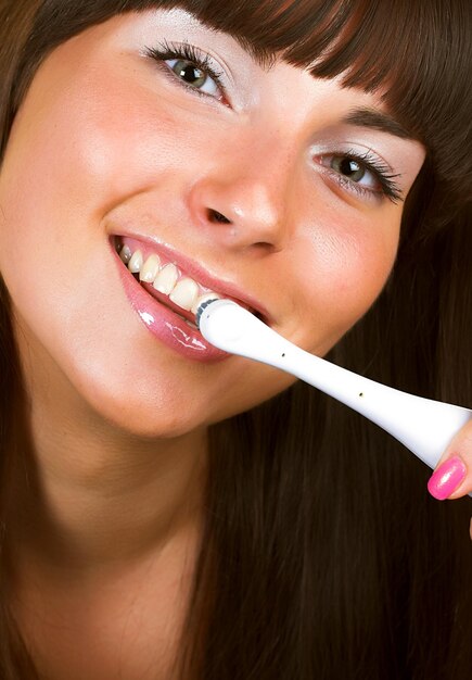 Jonge mooie glimlachende vrouw met grote witte tanden die bij . houden