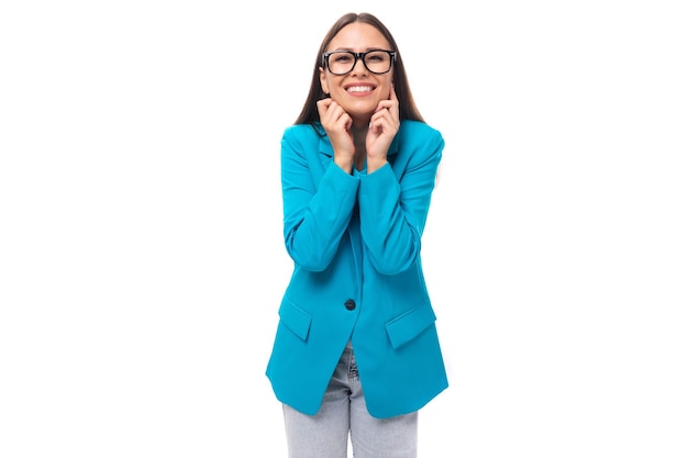 Jonge mooie kantoormedewerker vrouw in een blauwe zakenjas ziet er succesvol en gelukkig uit op een witte