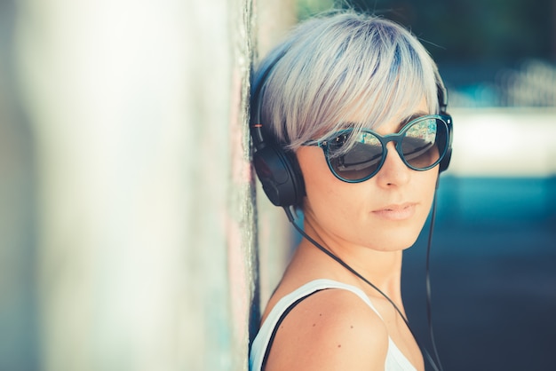 jonge mooie korte blauwe haren hipster vrouw met hoofdtelefoon muziek