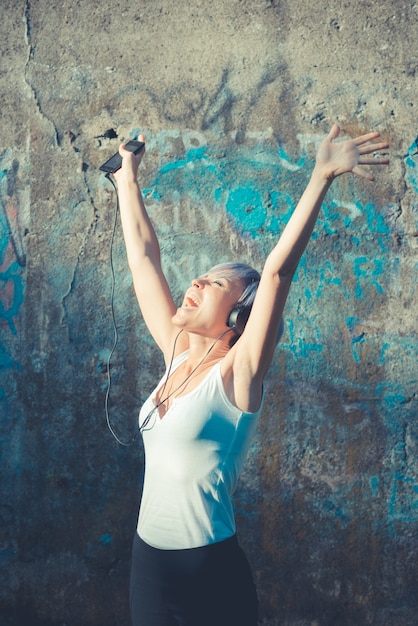 jonge mooie korte blauwe haren hipster vrouw met hoofdtelefoon muziek