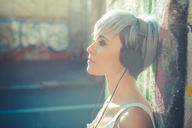 jonge mooie korte blauwe haren hipster vrouw met hoofdtelefoon muziek
