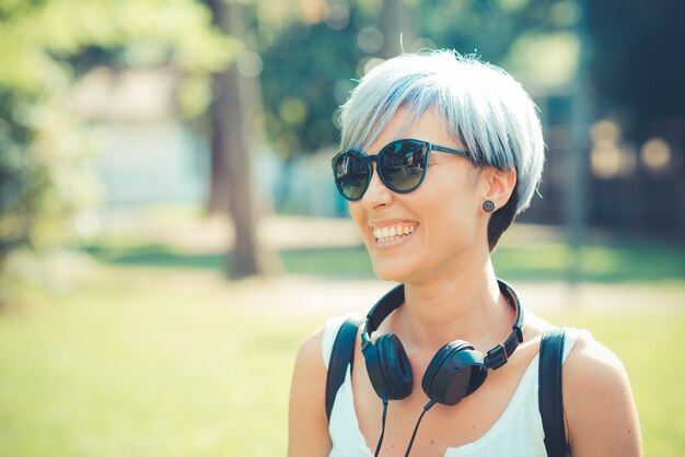 jonge mooie korte blauwe haren hipster vrouw met hoofdtelefoon muziek