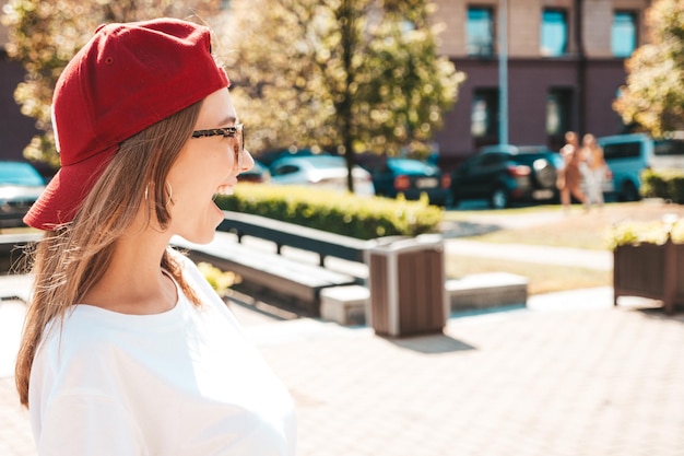 Jonge mooie lachende hipster vrouw in trendy zomerkleren sexy zorgeloze vrouw die zich voordeed op de straat achtergrond in glb bij zonsondergang positief model buitenshuis vrolijk en gelukkig in zonnebril