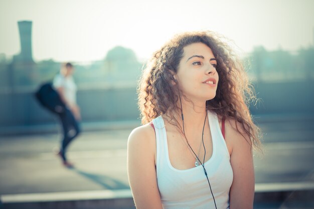 jonge mooie lange krullende haar hipster vrouw het luisteren muziek