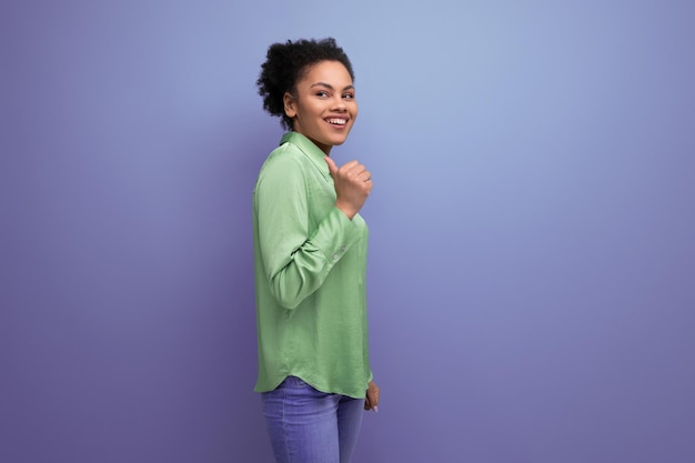 Jonge mooie Latijnse zakenvrouw in een groen shirt wijst haar hand naar de zijkopie ruimte