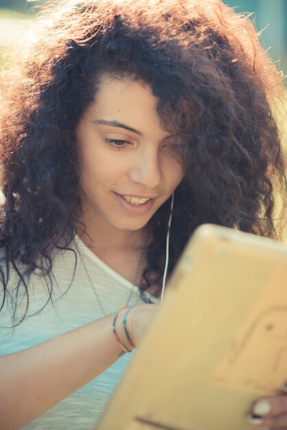 jonge mooie Marokkaanse krullende vrouw met behulp van Tablet PC