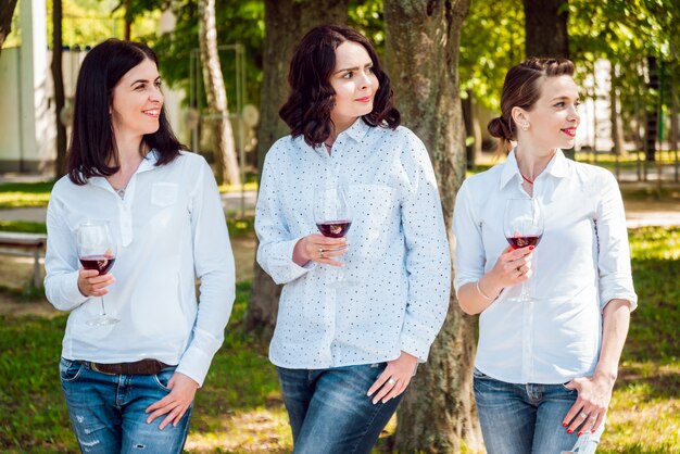 Jonge mooie meisjes met een glas rode wijn in het park