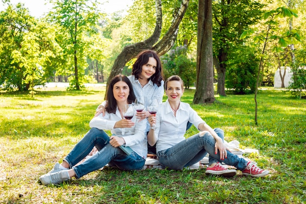 Jonge mooie meisjes met een glas rode wijn in het park