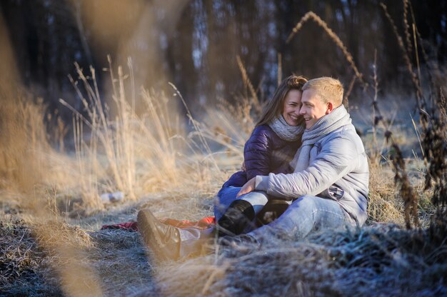 Jonge mooie mode sensuele paar verliefd zitten in winter koude veld