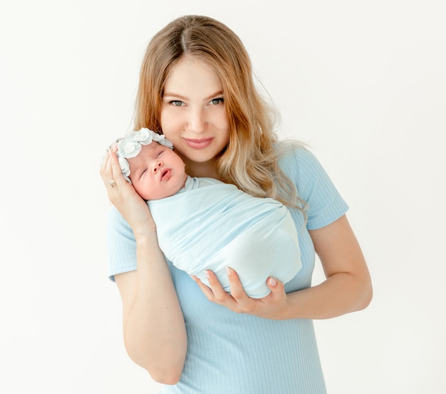 Jonge mooie moeder die een pasgeboren dochter houdt