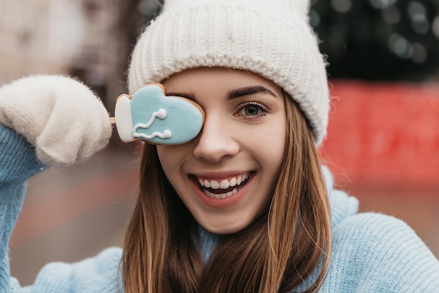 Jonge mooie mooie vrouw die op straat staat en peperkoek snoep chocoladekoekjes eet op een stokje