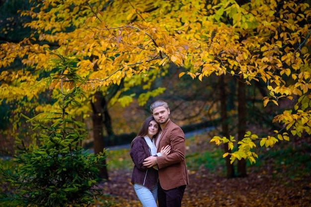 Jonge mooie paar knuffels in de herfst park.