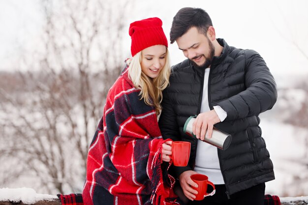 Jonge mooie paar op een picknick in de winter drinken ze koffie