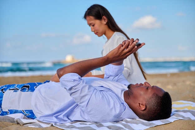 Jonge mooie paar rust op het strand man met smartphone