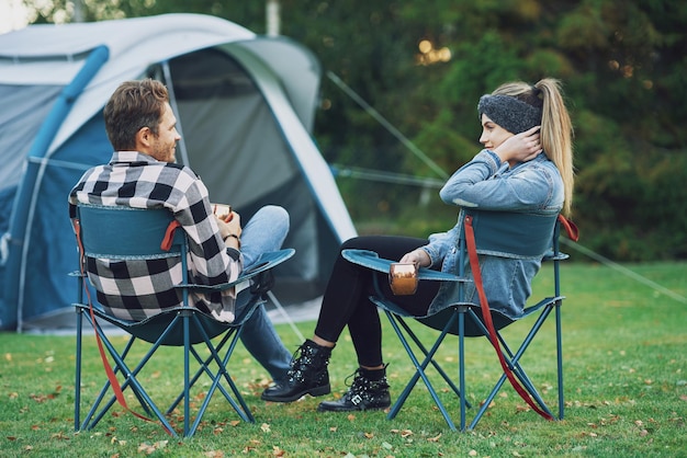 Jonge mooie paar zittend op stoelen voor tent op camping. hoge kwaliteit foto