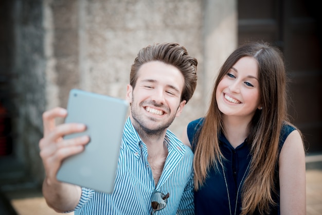 jonge mooie paarminnaars die tablet gebruiken