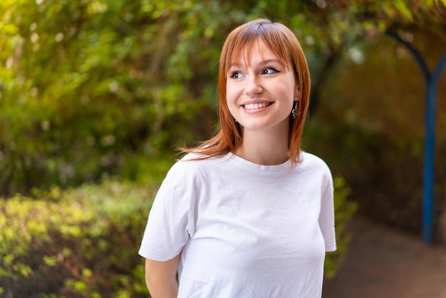 Jonge mooie roodharige vrouw buitenshuis Portrait