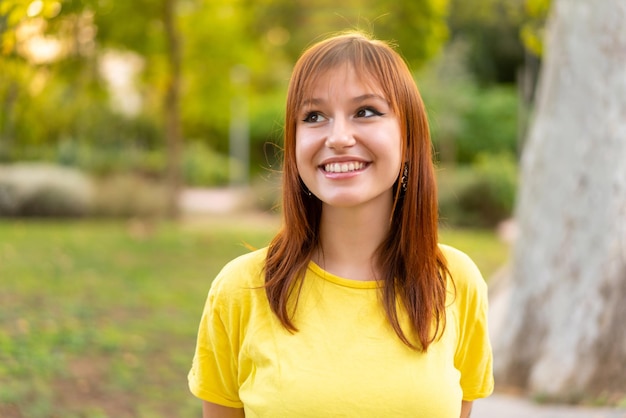 Jonge mooie roodharige vrouw buitenshuis Portrait