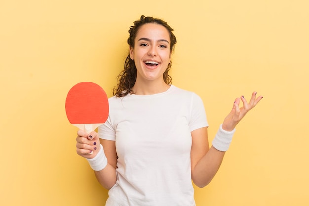 Jonge mooie Spaanse vrouw die blij verrast is en een pingpongconcept voor een oplossing of idee realiseert