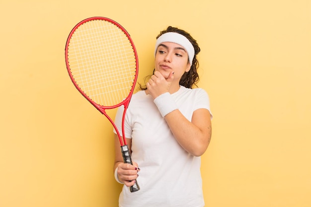 Jonge mooie Spaanse vrouw die denkt twijfelachtig en verward tennisconcept te voelen