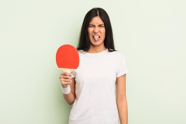 Jonge mooie Spaanse vrouw die walgt en geïrriteerd voelt en een pingpongconcept uitspreekt