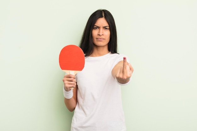 Jonge mooie Spaanse vrouw die zich boos voelt, geïrriteerd opstandig en agressief pingpongconcept