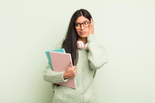 Jonge mooie spaanse vrouw die zich verveeld, gefrustreerd en slaperig voelt na een vermoeiende studentenconcept