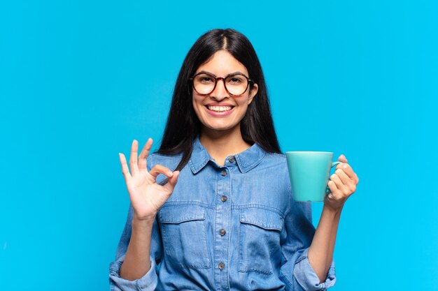 Jonge mooie Spaanse vrouw met een kopje koffie