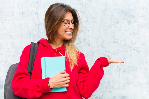 Jonge mooie student gelukkig voelen en glimlachen terloops op zoek naar een object of concept aan de kant aan de kant gehouden