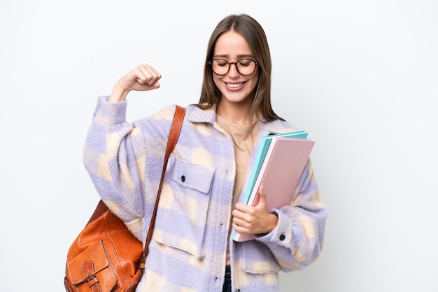 Jonge mooie studentenvrouw die op witte achtergrond wordt geïsoleerd die sterk gebaar doet