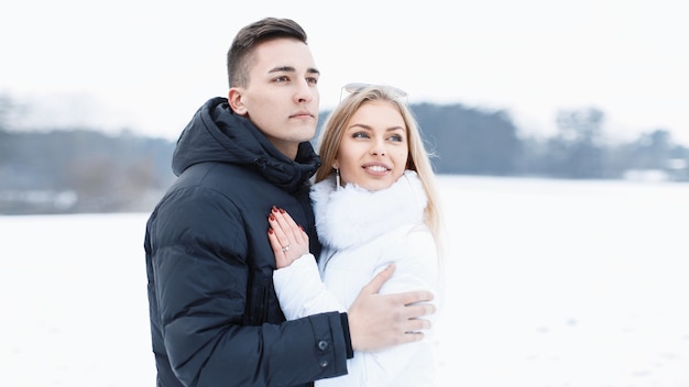 Jonge mooie verliefde paar staande in een veld op een winterse dag