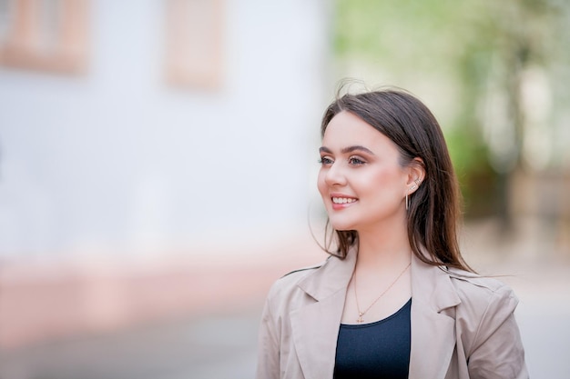 Jonge mooie vrouw 19 jaar oud in stijlvolle kleding Model met donker haar in vrijetijdskleding loopt door de lente bloeiende stad Warm