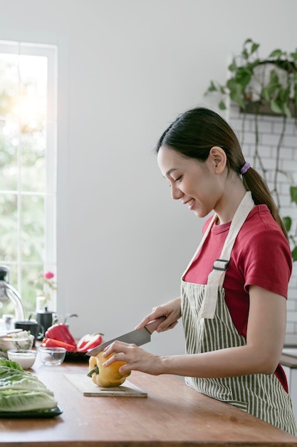 Jonge mooie vrouw bereidt het koken van gezond voedsel voor van verse groenten en fruit in de keukenruimte