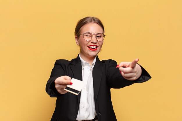 Jonge mooie vrouw blij en verrast uitdrukking creditcard concept