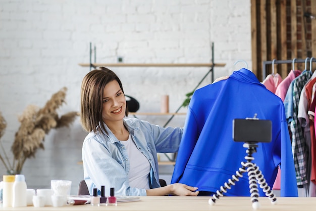 Jonge mooie vrouw blogger kleren tonen op camera