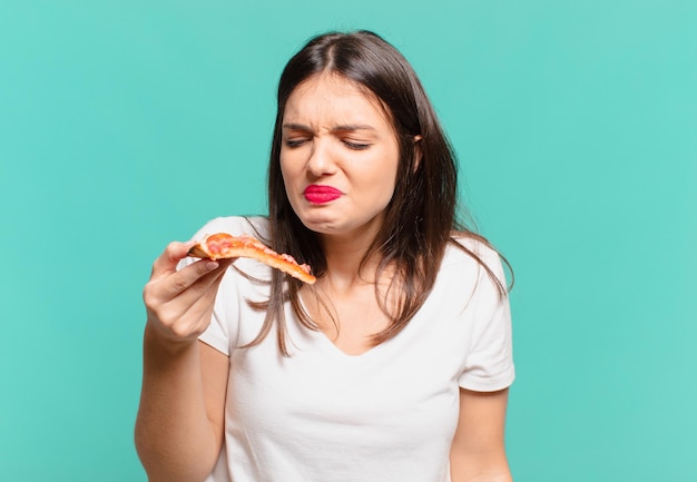 Jonge mooie vrouw boze uitdrukking en met een pizza