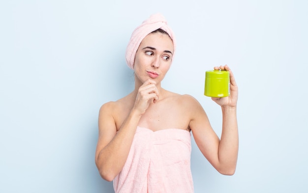 Jonge mooie vrouw denken, twijfelachtig en verward voelen. douche- en haarproductconcept