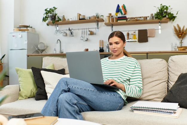 Jonge mooie vrouw die aan een laptop werkt in een gezellige moderne woonkamer met planten rond
