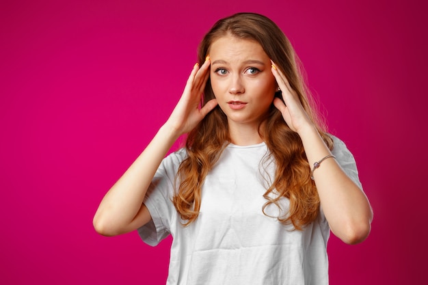 Jonge mooie vrouw die aan hoofdpijn met handen op hoofd lijdt close-up