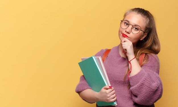 Jonge mooie vrouw die denkt of twijfelt aan het concept van de student van de uitdrukking