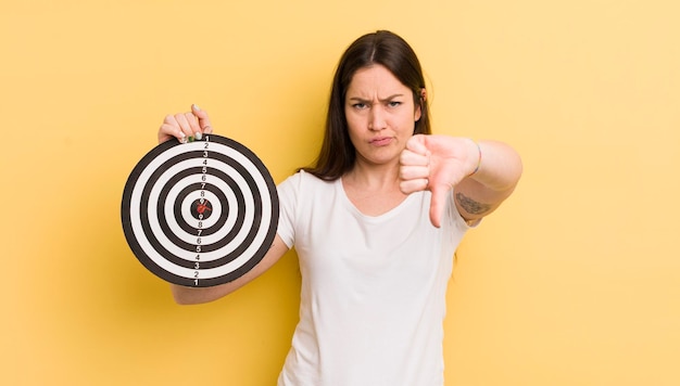 Jonge mooie vrouw die duimen naar beneden laat zien