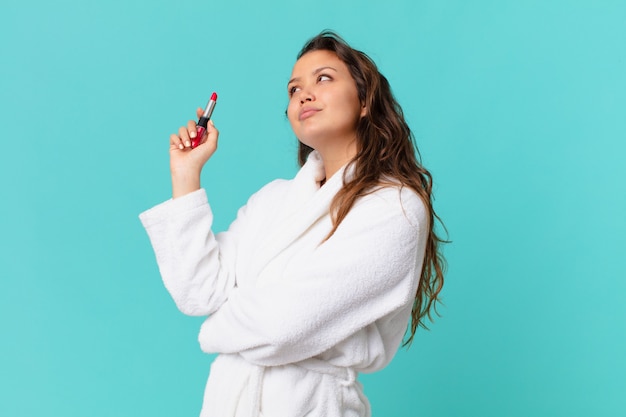 Jonge mooie vrouw die een badjas draagt