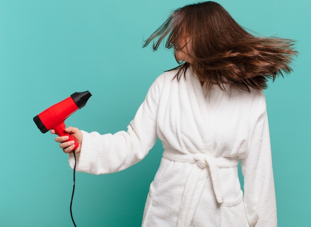 Jonge mooie vrouw die een gelukkige uitdrukking van een badjas draagt