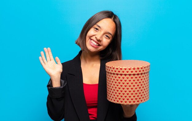 Jonge mooie vrouw die een giftdoos houdt