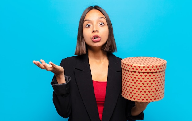 Jonge mooie vrouw die een giftdoos houdt