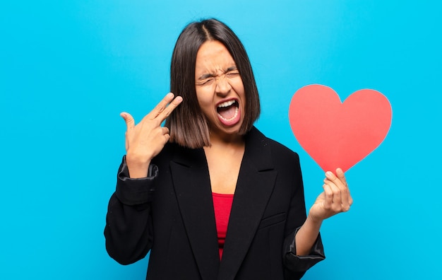 Jonge mooie vrouw die een hartkaart houdt