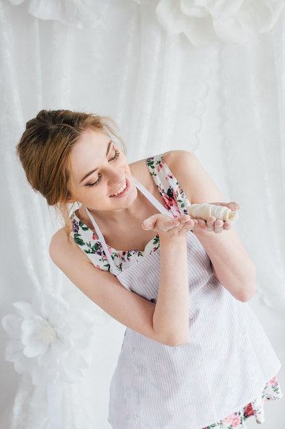 Jonge mooie vrouw die eigengemaakte croissants voorbereidt