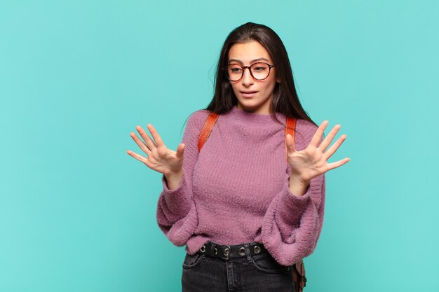 Jonge mooie vrouw die er nerveus, angstig en bezorgd uitziet en zegt dat het niet mijn schuld is