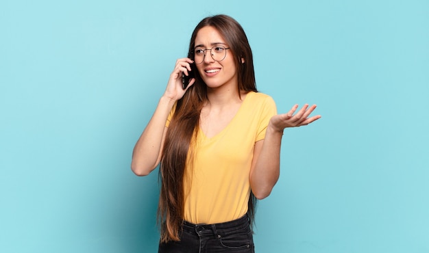 Jonge mooie vrouw die haar cellulair gebruikt.